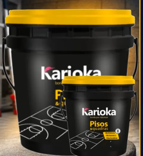 Baldes pretos da tinta Karioka Pisos e Quadras, com tampas amarelas.